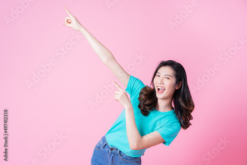 Portrait of young Asian woman on pink background