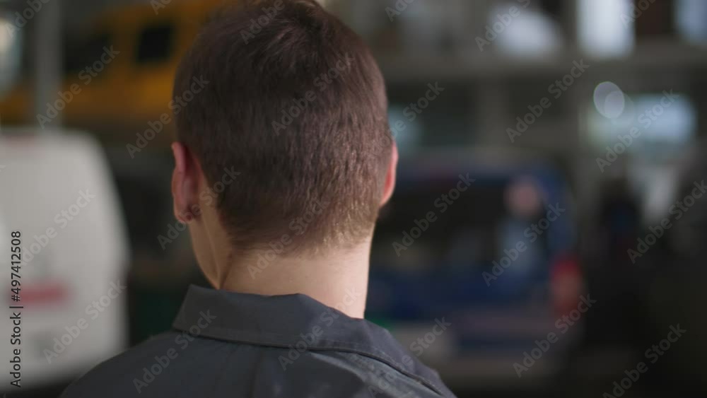 transport service, young male mechanic in uniform overseeing transport in car service, close-up transport service, young male mechanic in uniform overseeing transport in car service, close-up
