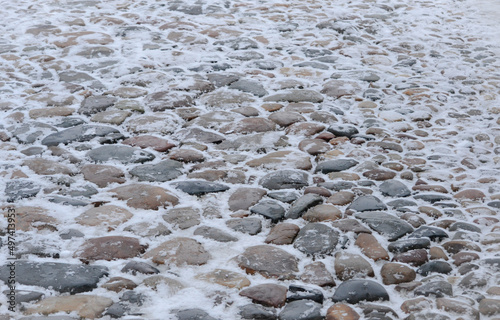 Close up cobblestone pavement in winter time. Textured, surface.