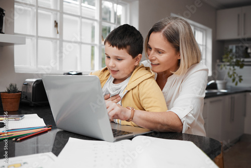 Lets log in for some work. Shot of a mother and son team using a laptop to complete home schooling work.