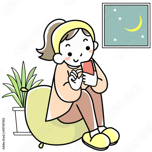 スマホを見ながら夜更かしする若い女性