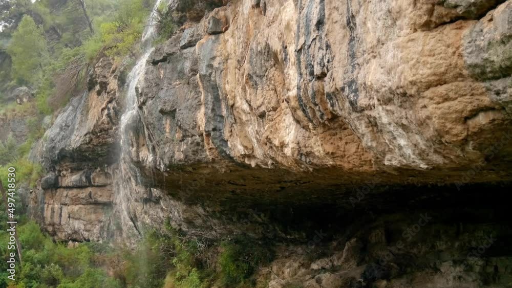 A cascade falling from a rocky feature over a large cave called Cueva del Gollizno in the small Spanish village of Chulilla A cascade falling from a rocky feature over a large cave called Cueva del Gollizno in the small Spanish village of Chulilla