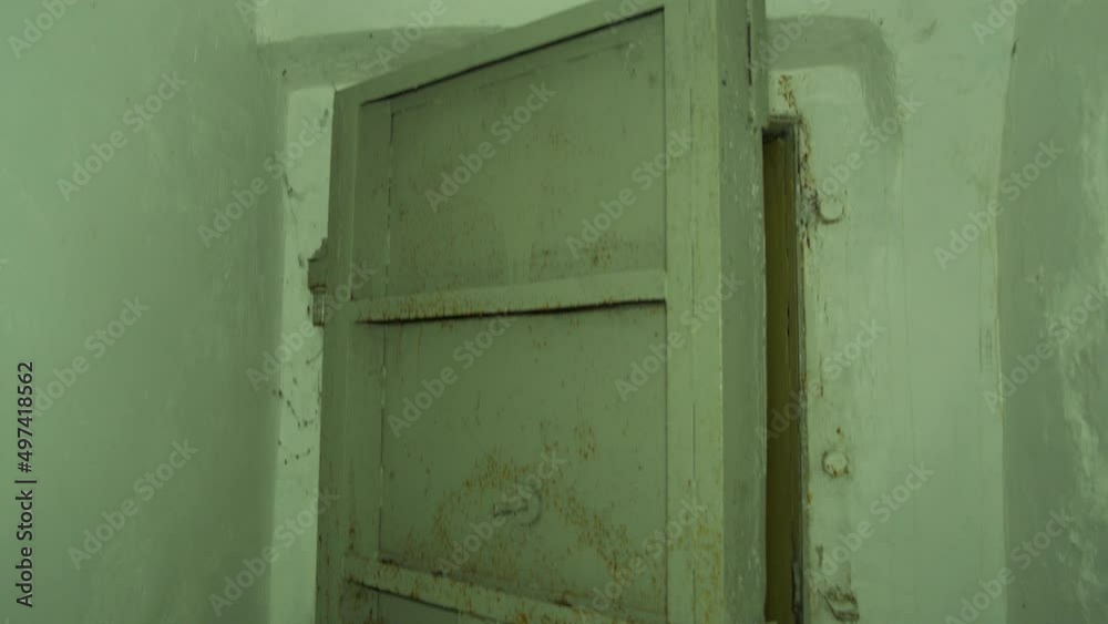 Steel door inside the concrete bomb shelter to hide civil people, an underground apocalypse bunker built in old coastal fortification, medium handheld shot tilt up Steel door inside the concrete bomb shelter to hide civil people, an underground apocalypse bunker built in old coastal fortification, medium handheld shot tilt up