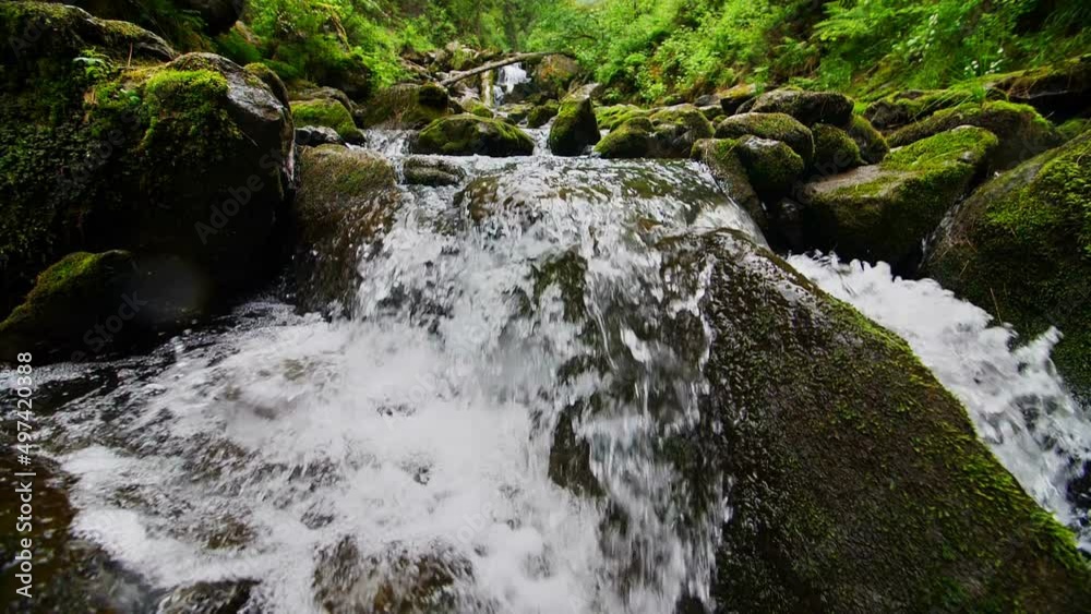 The mountain stream flows downward with cascades The mountain stream flows downward with cascades