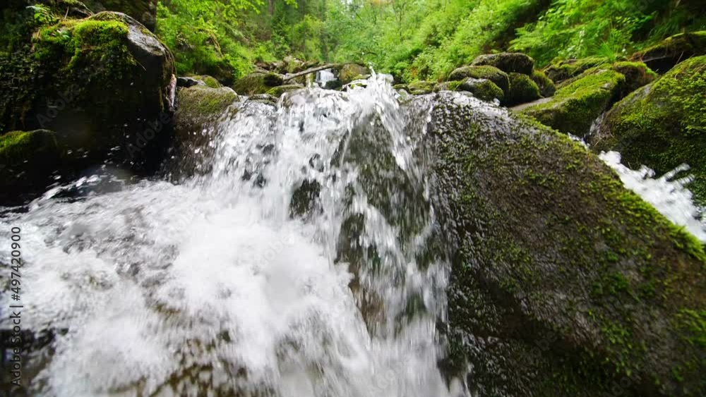 The mountain stream flows downward with cascades The mountain stream flows downward with cascades