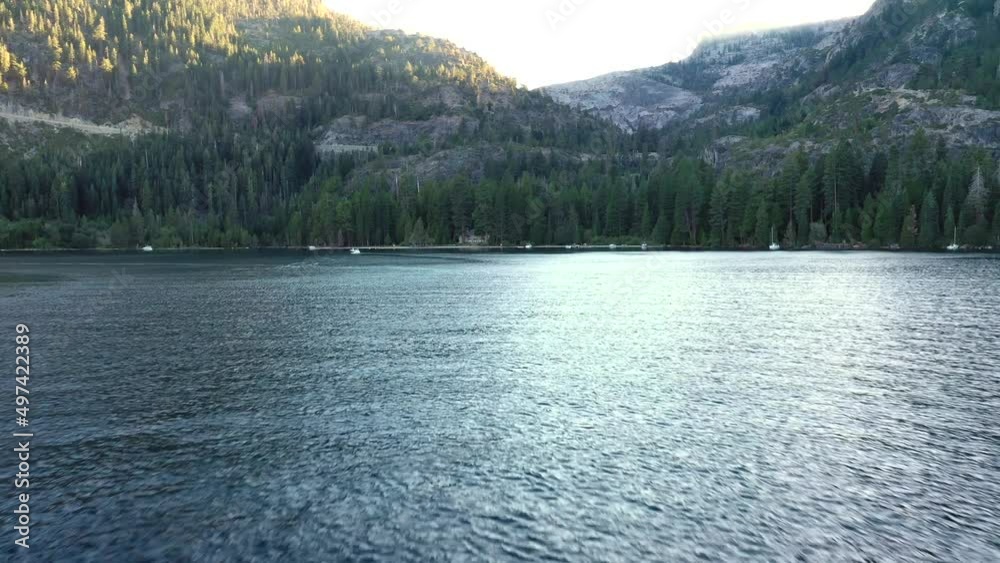 Forest Mountains On Serene South Lake Tahoe With Tourists Boating During Summer In California, United States. Aerial Pullback Shot Forest Mountains On Serene South Lake Tahoe With Tourists Boating During Summer In California, United States. Aerial Pullback Shot