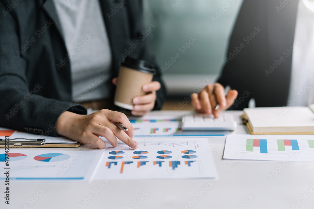 Business people using a calculator Think analyzing income, financial statements, balance sheet, company information. Business people using a calculator Think analyzing income, financial statements, balance sheet, company information.