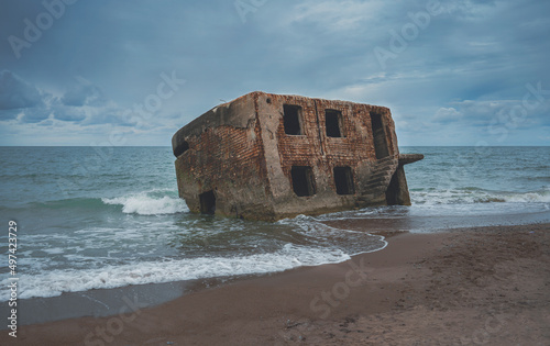 Fototapeta Naklejka Na Ścianę i Meble -  Destroyed frame of a house in the Baltic Sea. The remains of the military fort of the Russian army on the coast of Latvia in Liepaja. Fortifications are gradually destroyed by the sea.