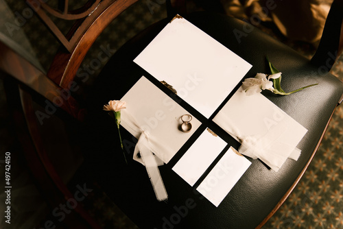 Wedding invitations and rings are white with an empty space on a dark background