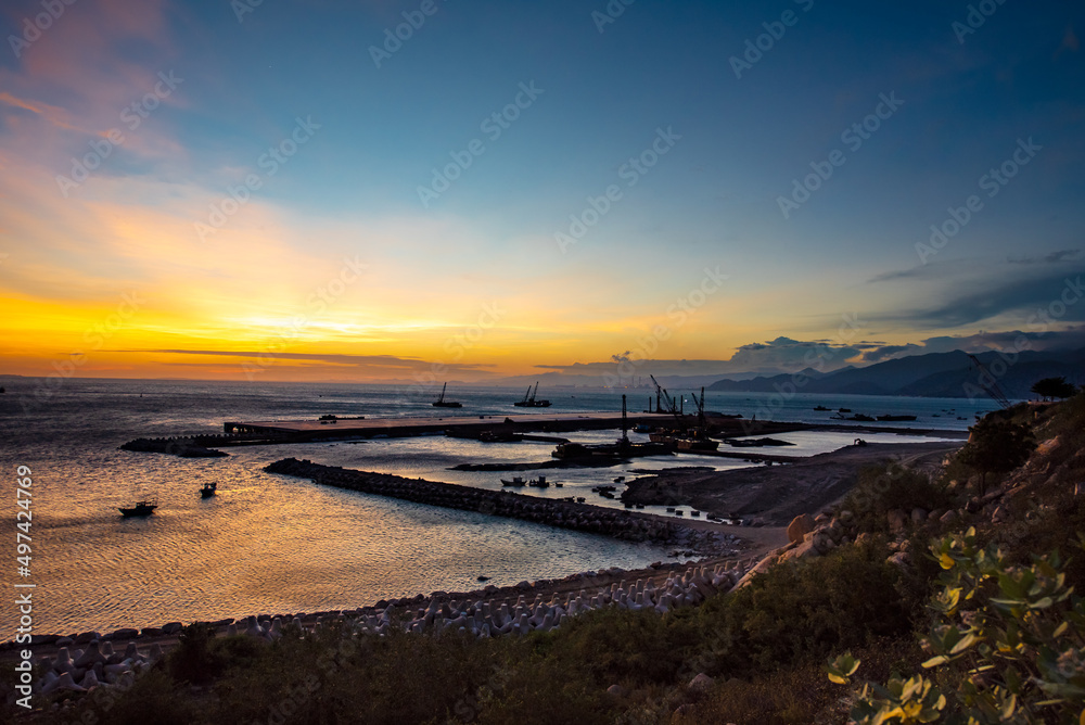 Obraz premium Seaport industry - Transportation and logistic . Industrial cranes and ships in the sunset.