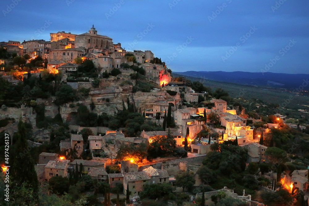 Landscape of Gordes, a beautiful small French town in the late evening at the background of the night sky and lights