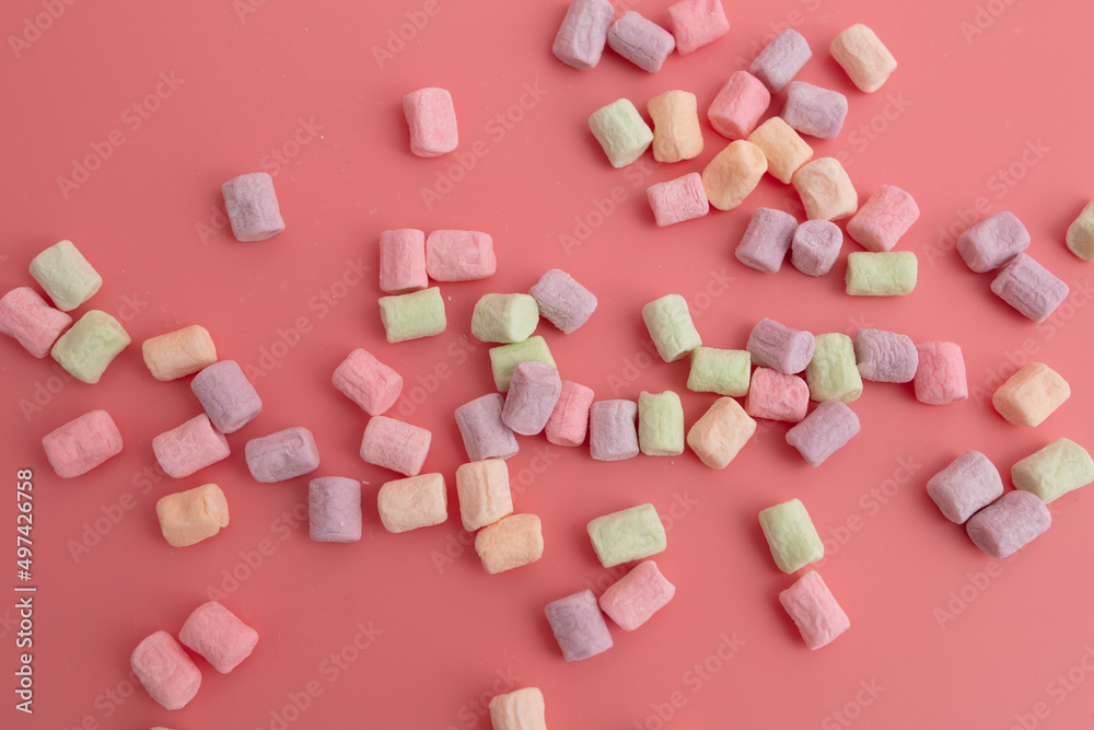 Multicolored candies on a pink background. Close-up Multicolored candies on a pink background. Close-up
