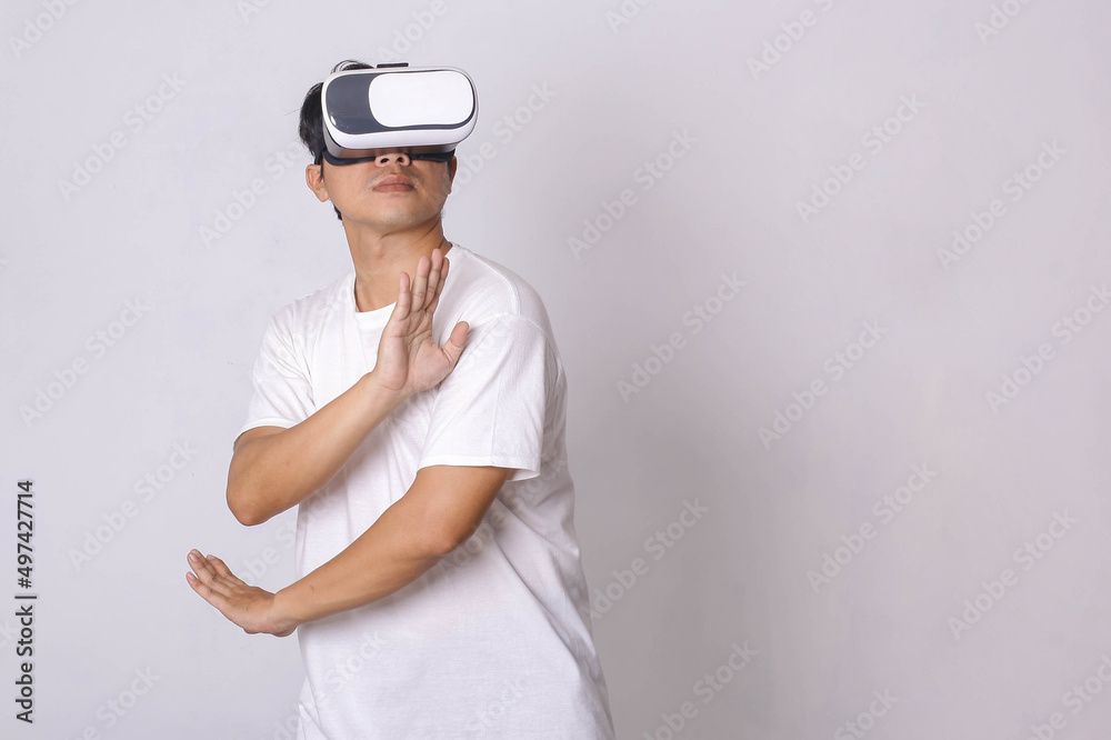 Asian man wearing VR goggles and practicing martial art workout at home, the concept of metaverse, virtual reality, activity, cyberspace and future Asian man wearing VR goggles and practicing martial art workout at home, the concept of metaverse, virtual reality, activity, cyberspace and future