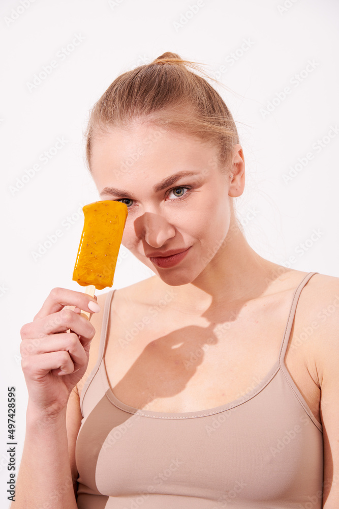 Portrait of sensuality young beautiful woman eating yellow sweet ice-cream Portrait of sensuality young beautiful woman eating yellow sweet ice-cream