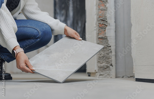 Fotobehang Designer architect checks and accepts work of master tiler on laying porcelain t