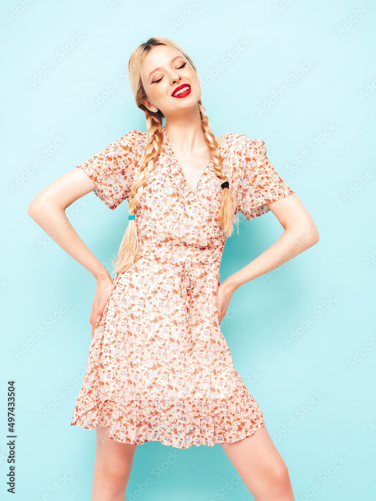 Young beautiful smiling female in trendy summer dress. Sexy carefree blond woman posing near blue wall in studio. Positive model having fun. Cheerful and happy Young beautiful smiling female in trendy summer dress. Sexy carefree blond woman posing near blue wall in studio. Positive model having fun. Cheerful and happy