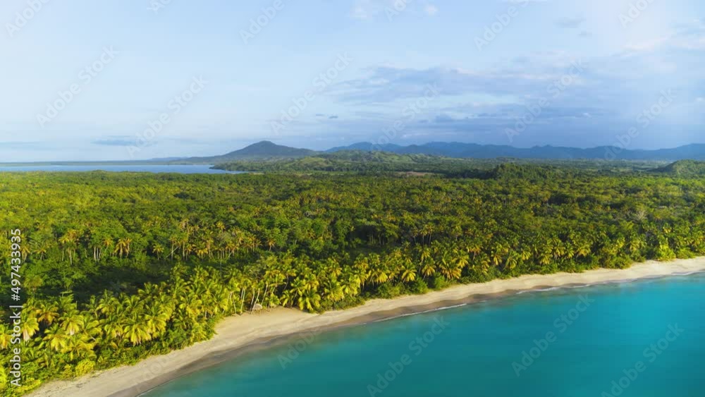 Wild palm beach Esmeralda in the rays of the dawn sun. Beautiful nature of Dominican Republic. Palm jungle on the tropical coast. Calm blue sea near the sandy shore. Journey to a tropical paradise. Wild palm beach Esmeralda in the rays of the dawn sun. Beautiful nature of Dominican Republic. Palm jungle on the tropical coast. Calm blue sea near the sandy shore. Journey to a tropical paradise.