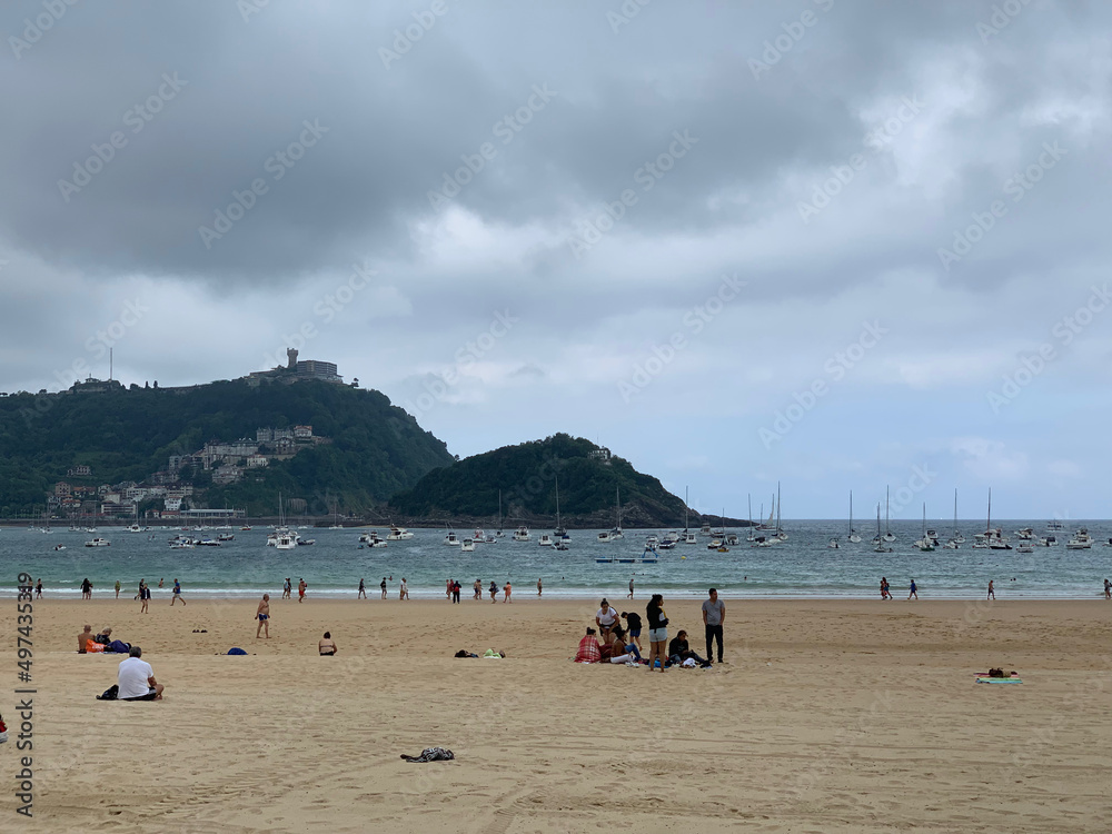 Obraz premium People enjoying summer day at San Sebastian beach La Concha in Basque Country
