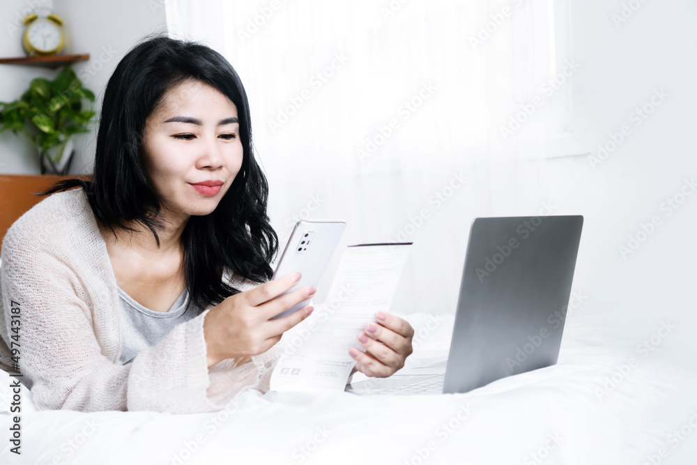 happy Asian woman paying bills online from home hand holding smart phone scanning qr code happy Asian woman paying bills online from home hand holding smart phone scanning qr code