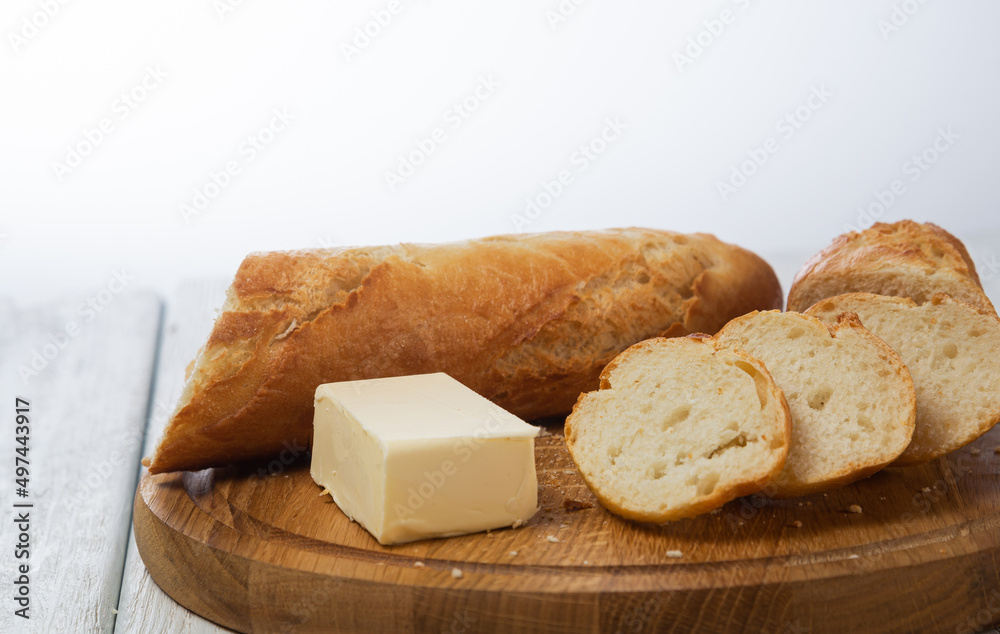 Fresh baguette. Sliced baguette with butter Fresh baguette. Sliced baguette with butter