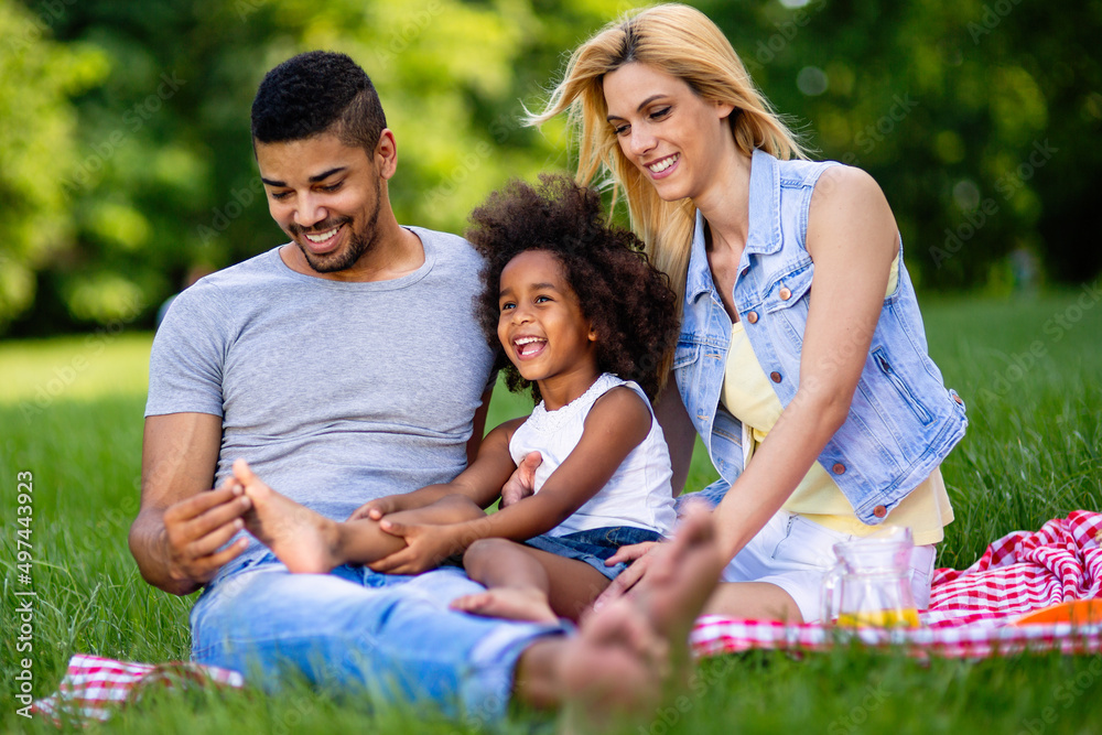 Happy multiethnic family enjoying picnic in nature Happy multiethnic family enjoying picnic in nature