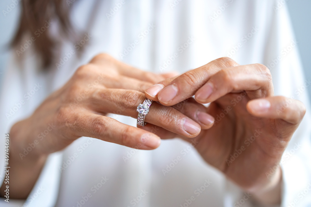 Close up of decisive woman take off wedding ring make decision breaking up with husband, young female remove engagement jewelry having relationships problems filing for divorce or annulment - obrazy, fototapety, plakaty 