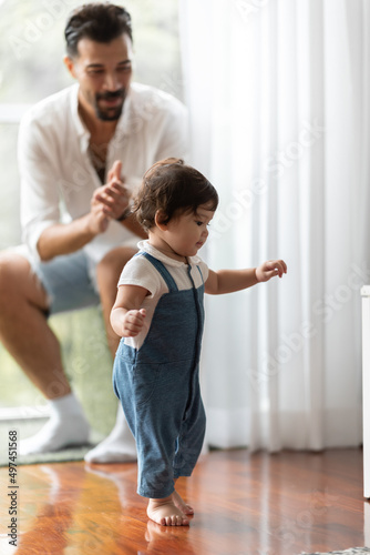 cute toddler little child family concept  baby learning to walk with father and mother to help care and holding hand  first step with childhood parent support  small love portrait little boy at home