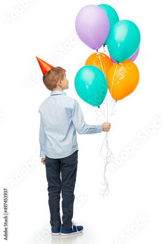 birthday, childhood and people concept - portrait of smiling little boy in party hat with balloons over white background