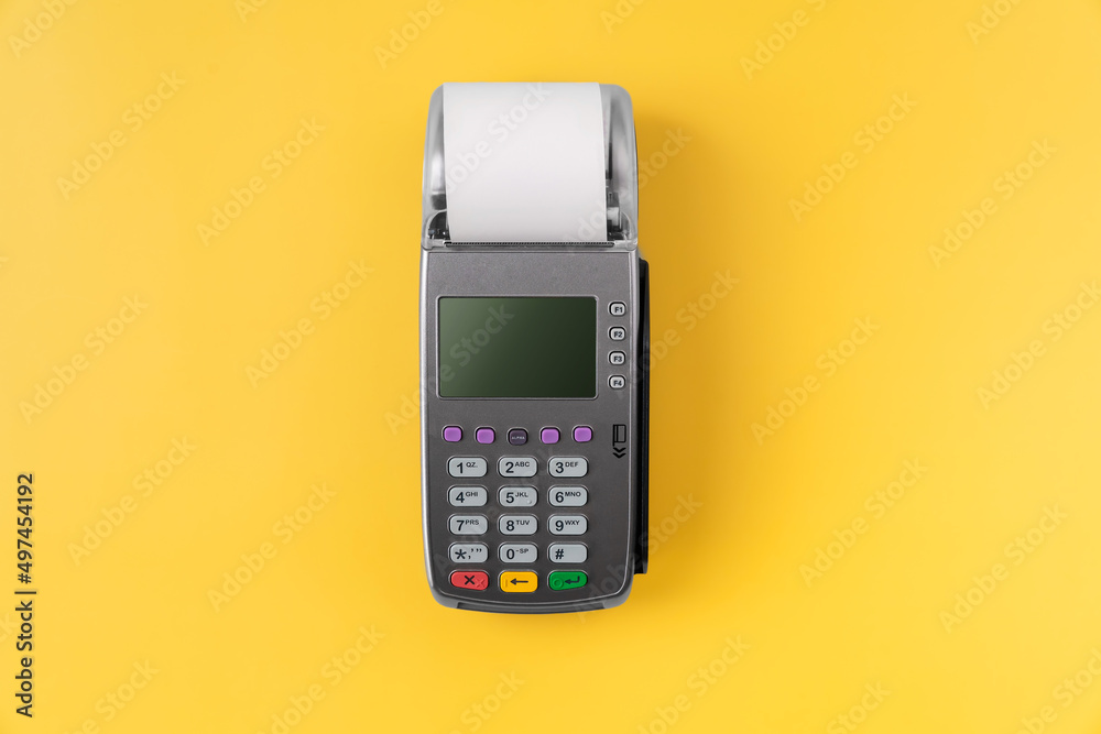Card reader machine with invoice bill on yellow background. Online payment concept.
