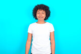 young woman with afro hairstyle wearing white T-shirt against blue wall nice-looking sweet charming cute attractive lovely winsome sweet peaceful closed eyes