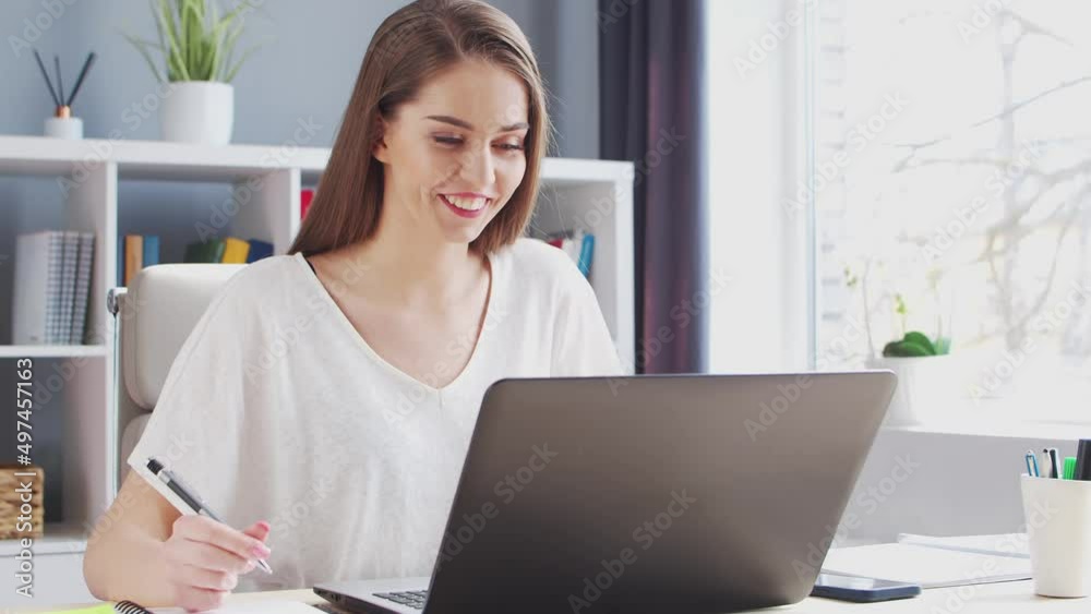 Young Woman Works at Home Office Using Computer. She has a Conference Call. Workplace of Female Entrepreneur, Freelancer or Student. Remote Work and Education Concept. Young Woman Works at Home Office Using Computer. She has a Conference Call. Workplace of Female Entrepreneur, Freelancer or Student. Remote Work and Education Concept.