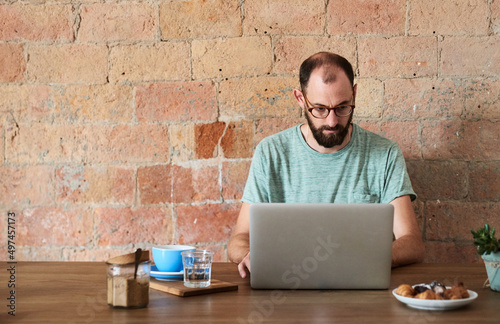 man working on laptop in cafe.