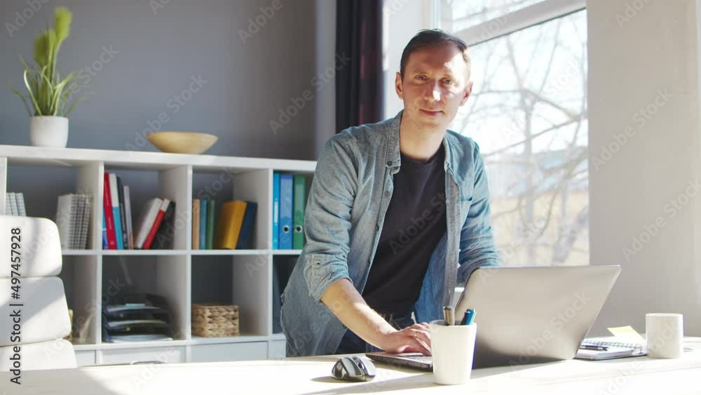Young male entrepreneur works at home office at the computer. Workplace of freelancer or student. Remote work and education concept. Young male entrepreneur works at home office at the computer. Workplace of freelancer or student. Remote work and education concept.