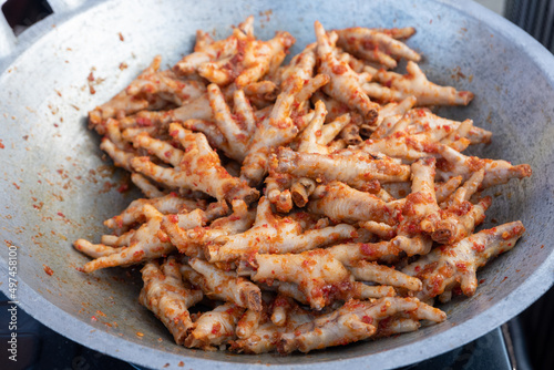 fried chicken feet in a frying pan and mixed with chili