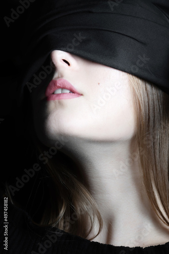 Beauty  sensual  makeup concept. Close-up studio shot of beautiful woman face covered with black ribbon. Model with pink lipstick  white teeth and bright skin cover her eyes with black fabric