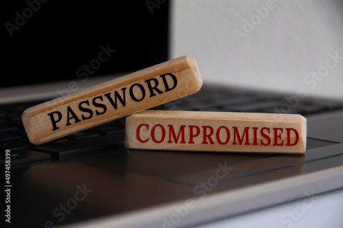 Password compromised text on wooden blocks on top of a laptop.