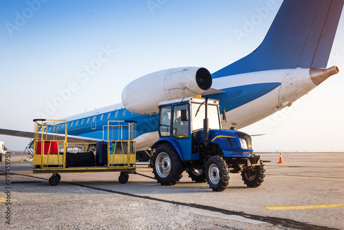 Loading luggage on the plane. Transportation of baggage in trailers to the aircraft