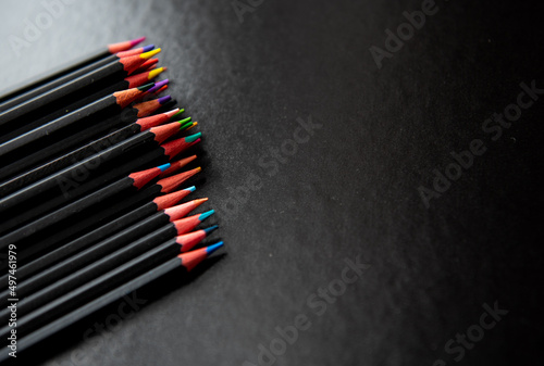 Crayons de couleur sur un fond noir avec de l'espace vide - coloriage et créativité