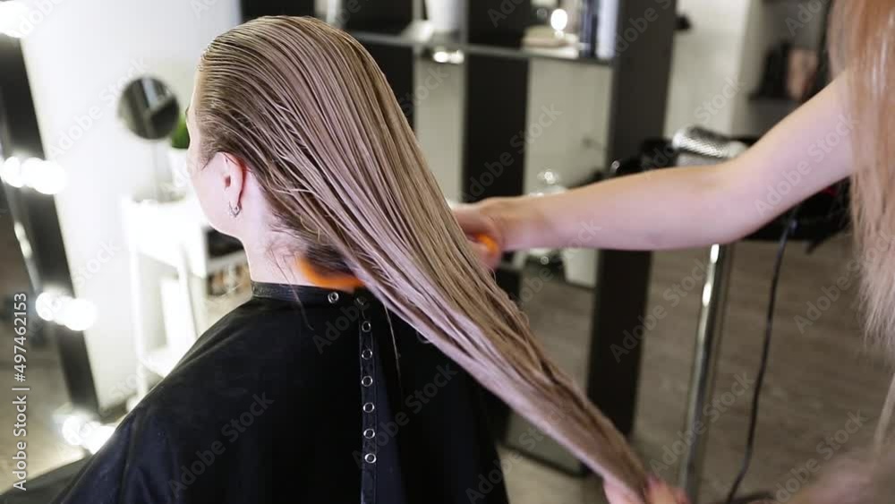 Drying long blonde hair with hair dryer and round brush Drying long blonde hair with hair dryer and round brush