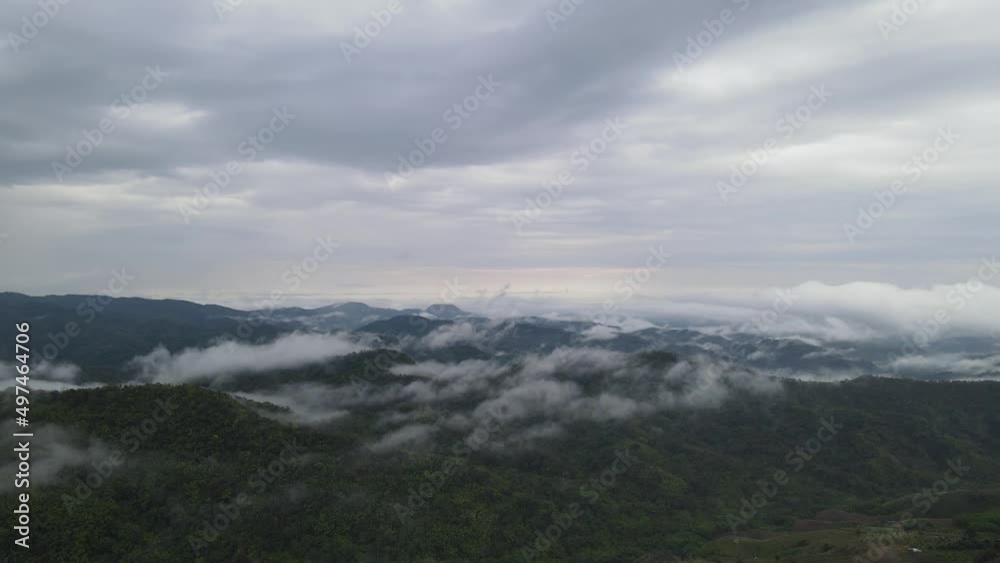 Mystical clouds and fog descending on hillside during sunrise aerial drone shot Mystical clouds and fog descending on hillside during sunrise aerial drone shot