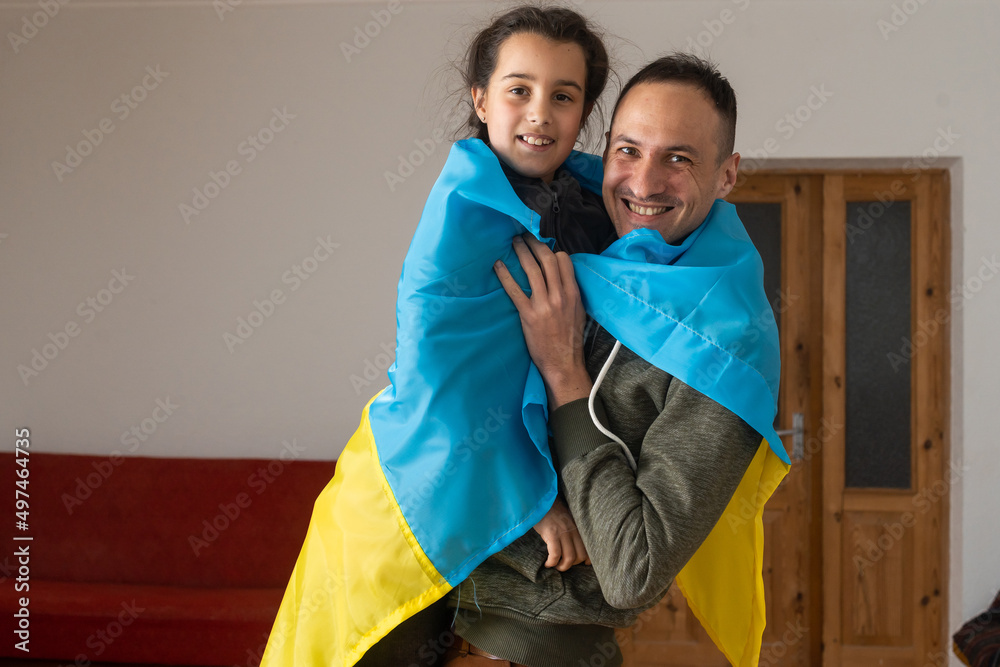 Obraz premium family with one child looking at camera and Ukrainian flag