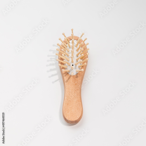 Wooden mini bamboo hair brush for travel  beard or kids on white background. Small pocket brush. Top view  copy space