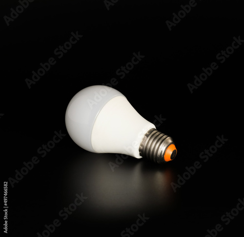 Economical LED light bulb with reflection on a black background