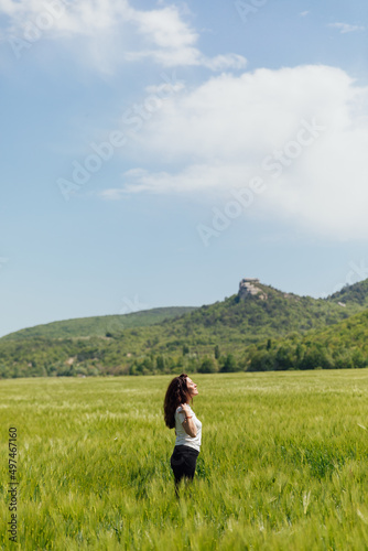 woman traveler in the field looks at the beautiful landscape © dmitriisimakov