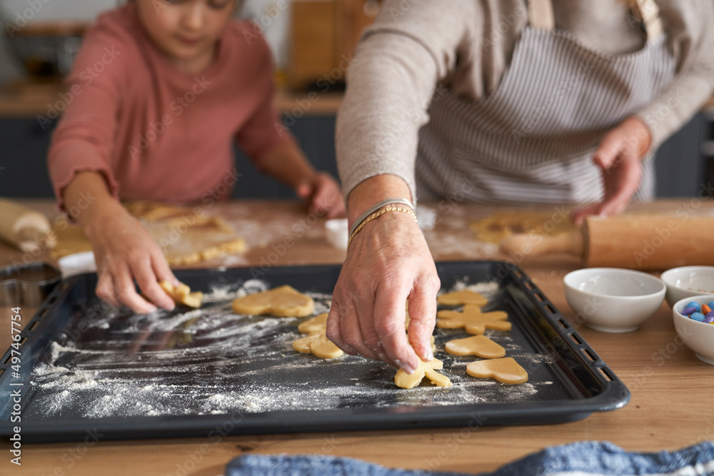 Caucasian girl with grandmother decorating cookies Caucasian girl with grandmother decorating cookies
