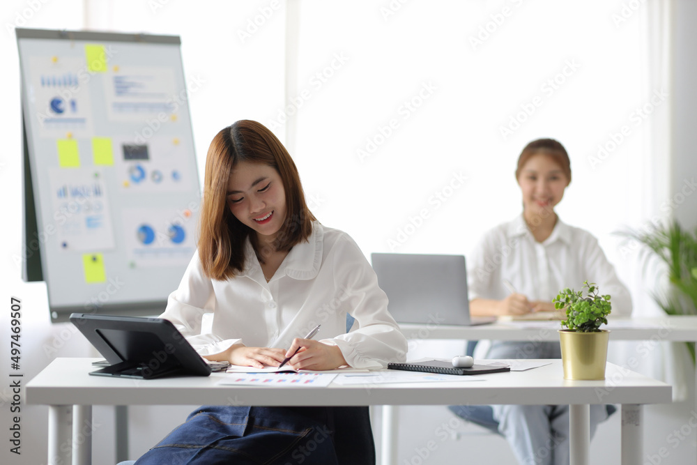 Young Asian businesswoman working in modern office with colleagues. Employee working on financial and marketing projects. Young Asian businesswoman working in modern office with colleagues. Employee working on financial and marketing projects.