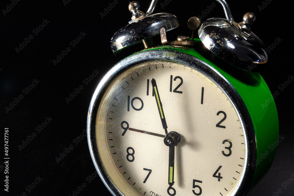Old green alarm clock isolated on black background Old green alarm clock isolated on black background