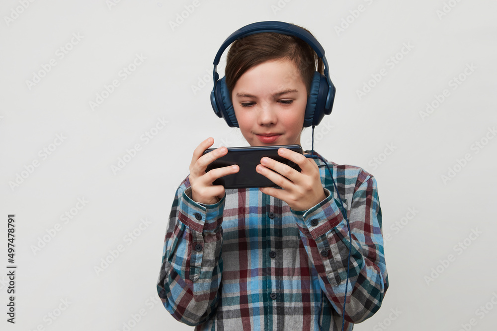 Boy using smartphone on a white background with copy space. Boy using smartphone on a white background with copy space.