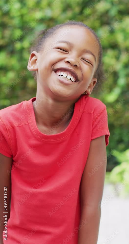 Vertical video of portrait of happy african american girl in garden Vertical video of portrait of happy african american girl in garden