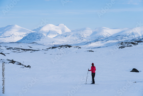 Female cross country skier with pulka (sled) in the snow in Lapland, Sweden.